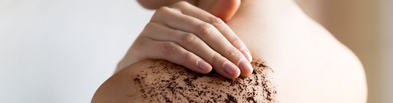 Exfoliante casero de café aplicado sobre el hombro. Rutina de exfoliación corporal para consentir tu piel y mantenerla suave.